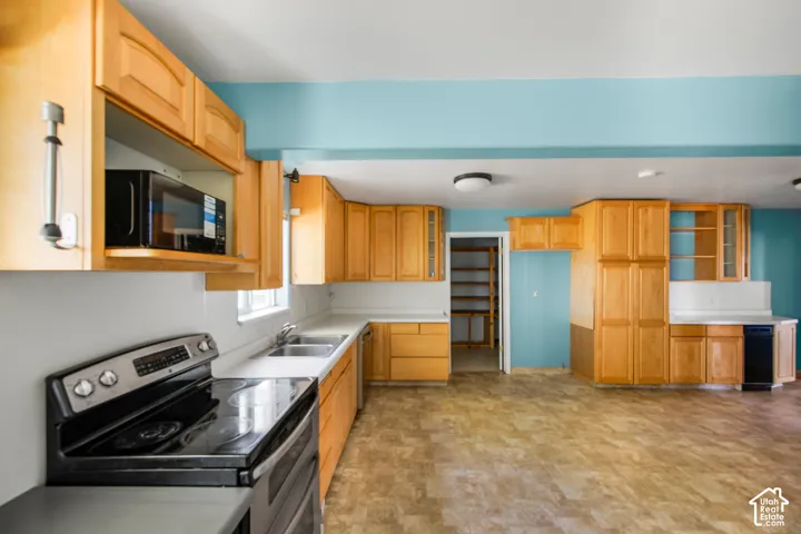 Expansive kitchen with wood-finish cabinetry, solid surface countertops, and a built-in microwave