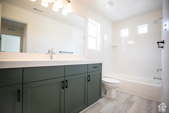 Full secondary bath with painted wood cabinets and quartz slab countertops.
