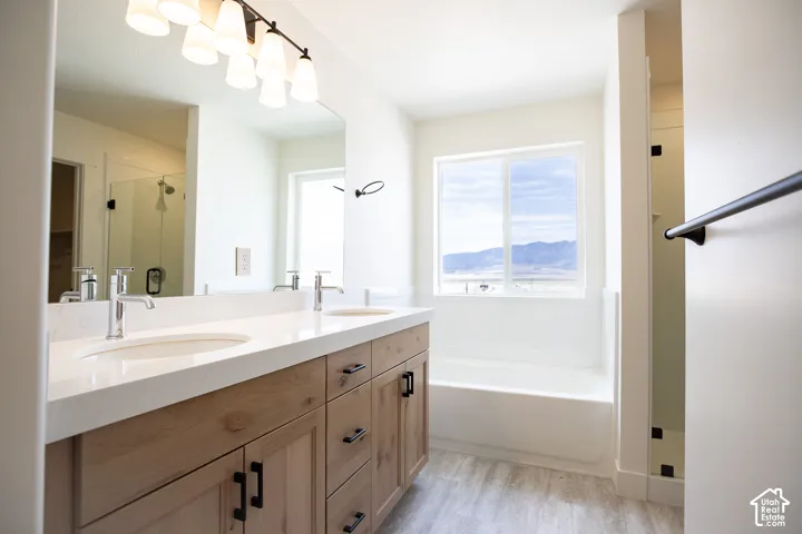 Primary bath with dual sinks, stained wood cabinets and quartz slab countertops.