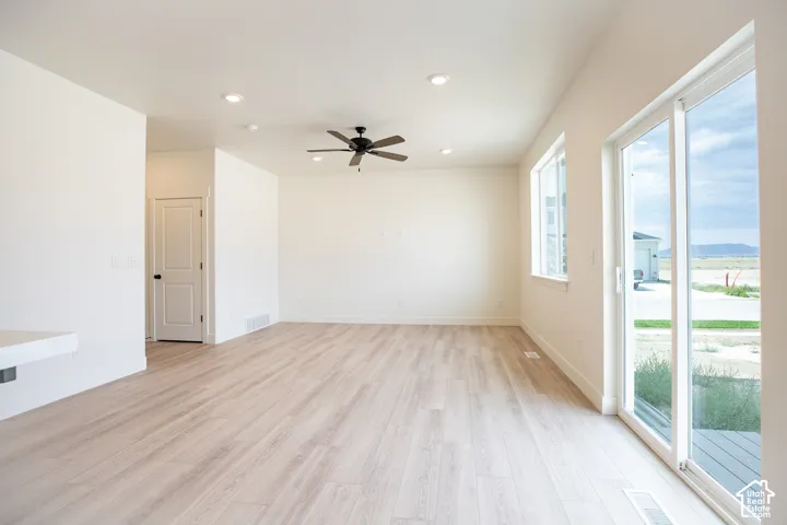 Large family room with sliding glass door, 9' ceiling and ceiling fan.
