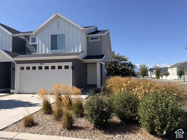 Contemporary exterior featuring board and batten siding, attached garage with panel inserts, and a covered entry
