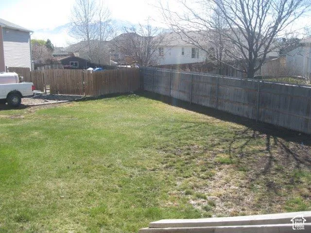 Expansive grassy yard with wood fencing