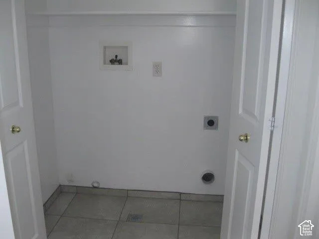 Utility closet with tile flooring and bi-fold doors