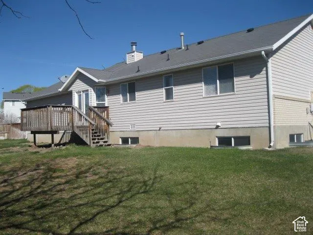 Exterior featuring light-colored siding, a multi-level deck, a shingle roof, and a partial brick facade