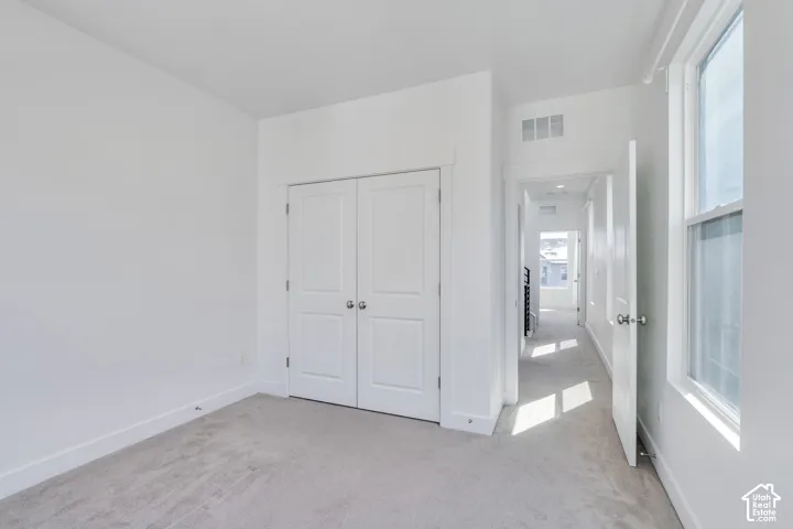 Neutral wall finishes, light-colored carpet, and a double-door closet