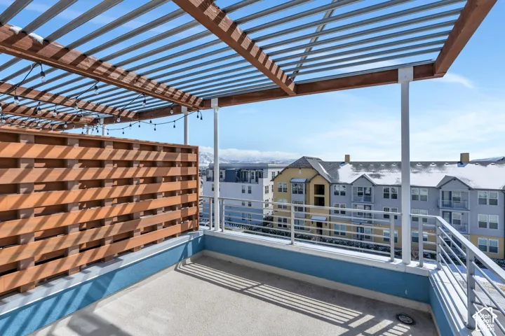 Outdoor patio featuring a slatted wood privacy wall, a wood and metal pergola, and metal railings
