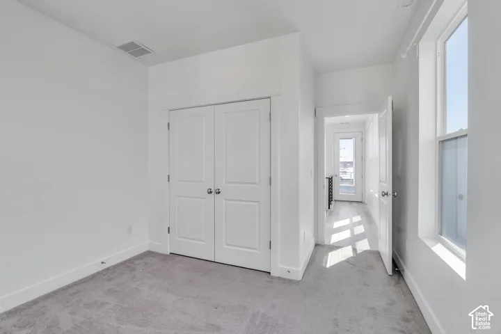 Neutral wall tones, gray carpeting, dual pane window, and white interior doors