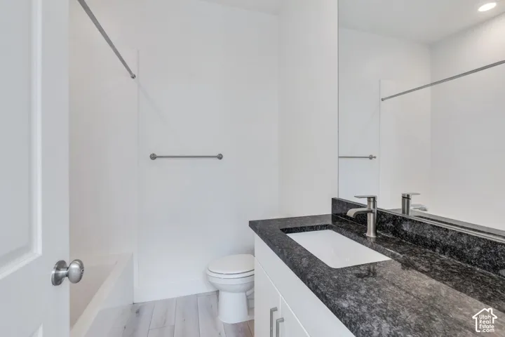 Bathroom featuring a contemporary vanity with a dark speckled countertop, undermount sink, and brushed nickel faucet