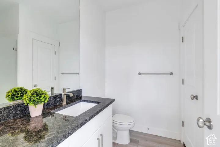 Vanity with a dark stone countertop, integrated rectangular sink, and chrome faucet