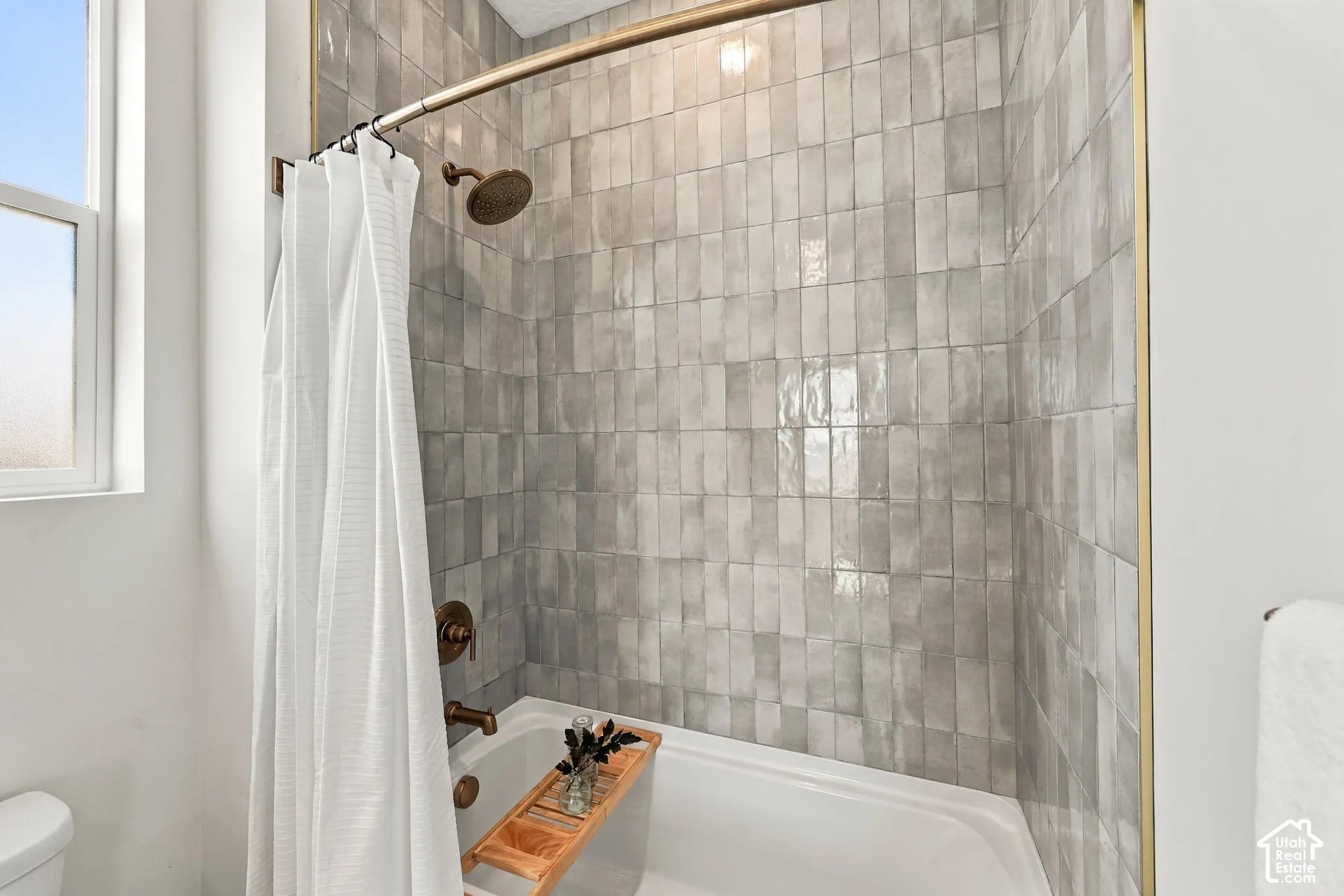 Shower-over-tub with matte bronze fixtures, subway tile surround, and a coordinating bronze shower rod