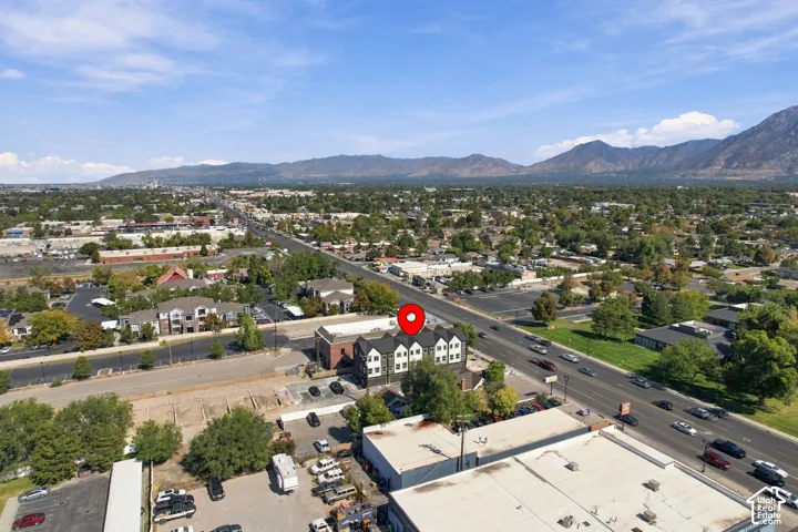 Terraced mountain range backdrop, prominent roadway access, mature tree coverage, and a dense urban landscape