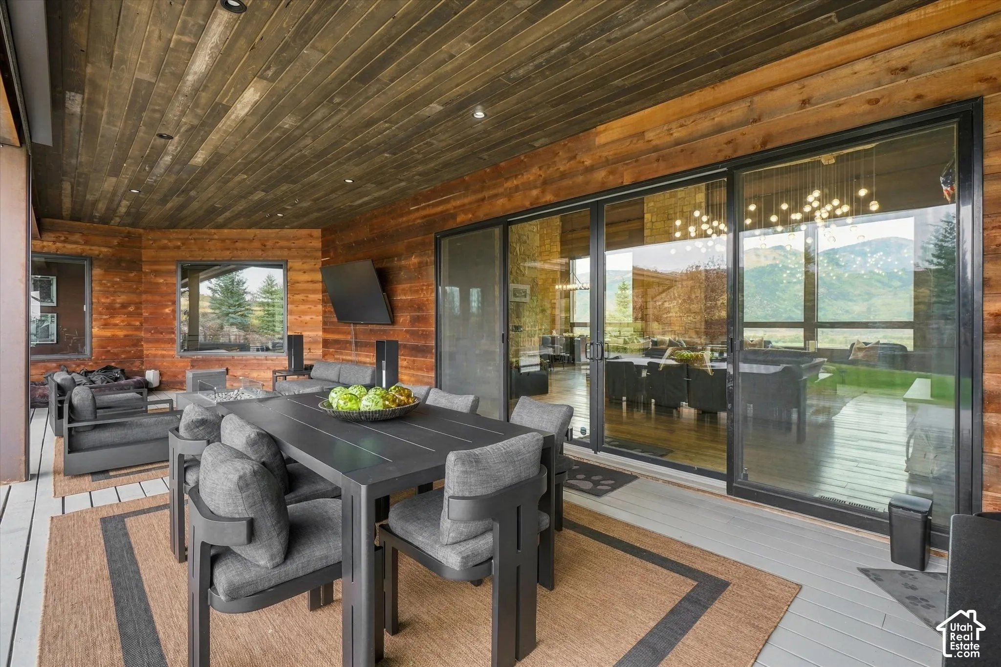 Covered patio featuring a wood-panel ceiling, wood-paneled walls, and sliding glass doors