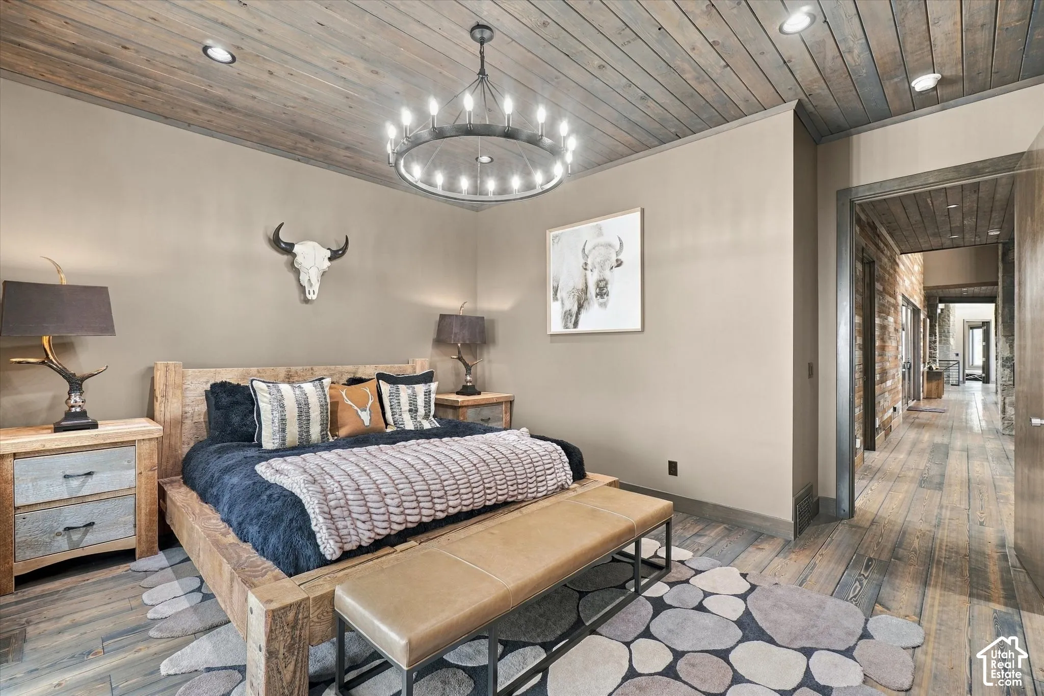Wood-plank ceiling and flooring, recessed lighting, and a chandelier-style fixture
