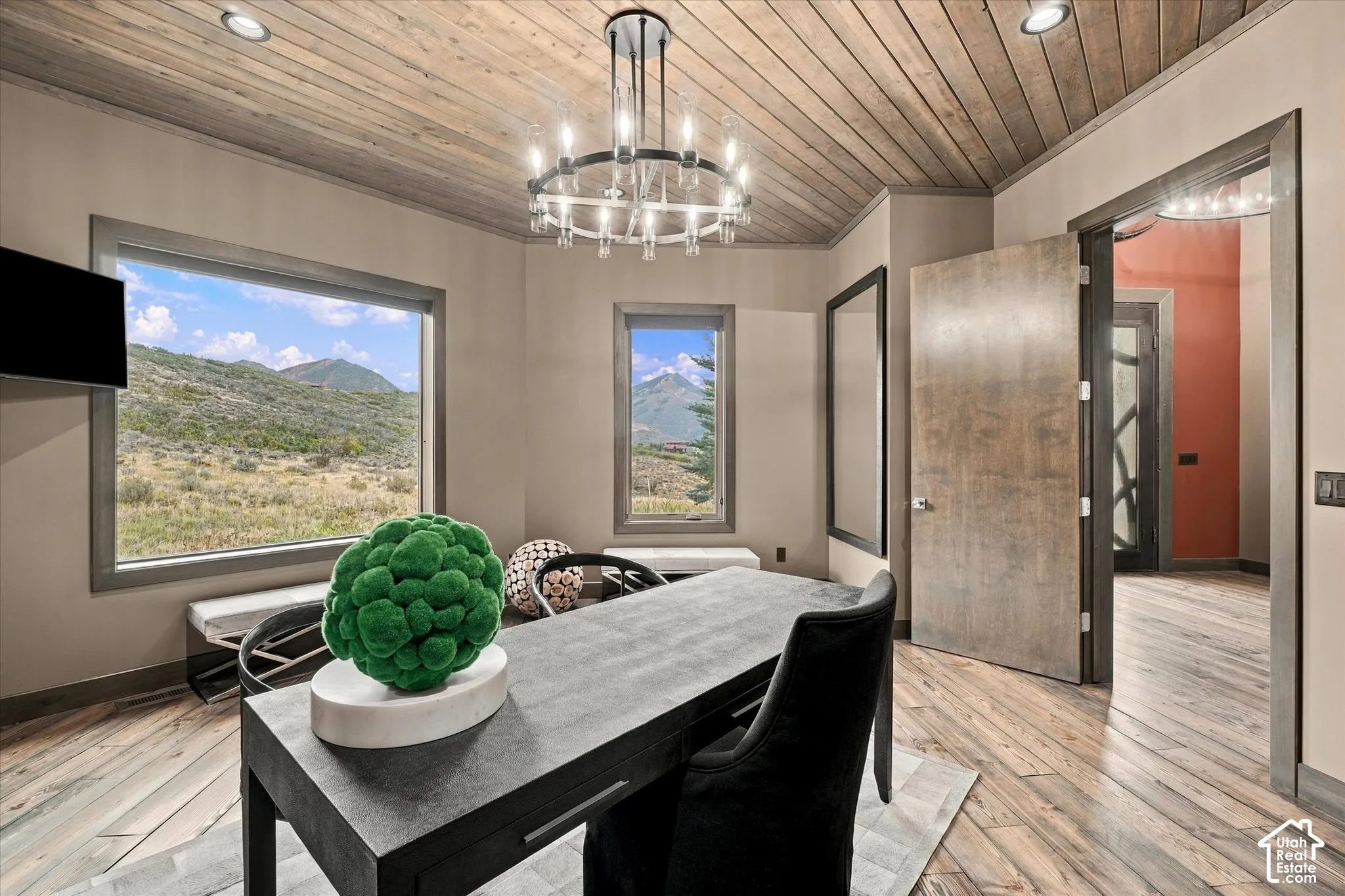 Wood-finish flooring, wood-paneled ceiling, and large windows