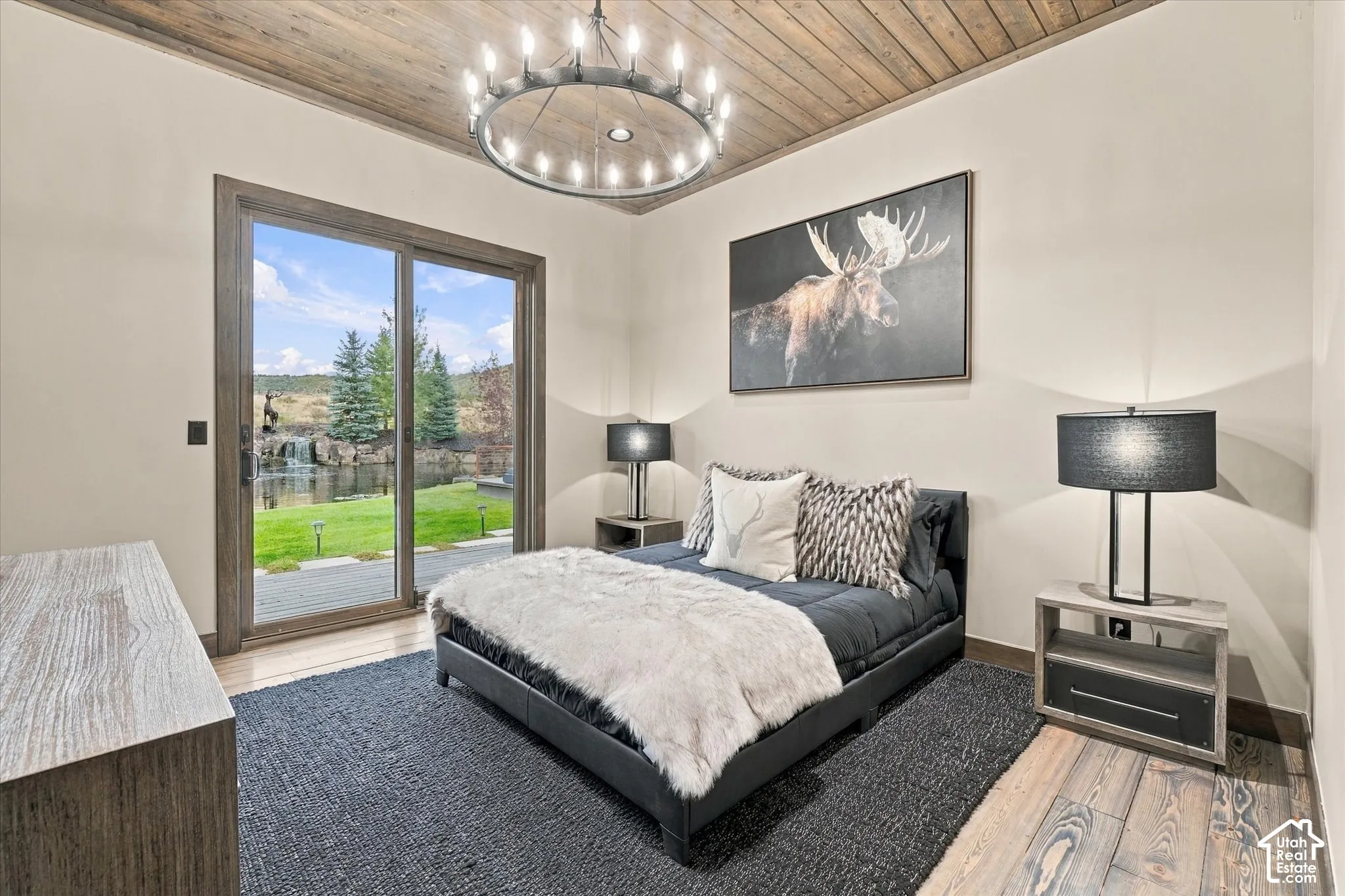 Hardwood flooring, wood-paneled ceiling, sliding glass door, recessed lighting, and chandelier