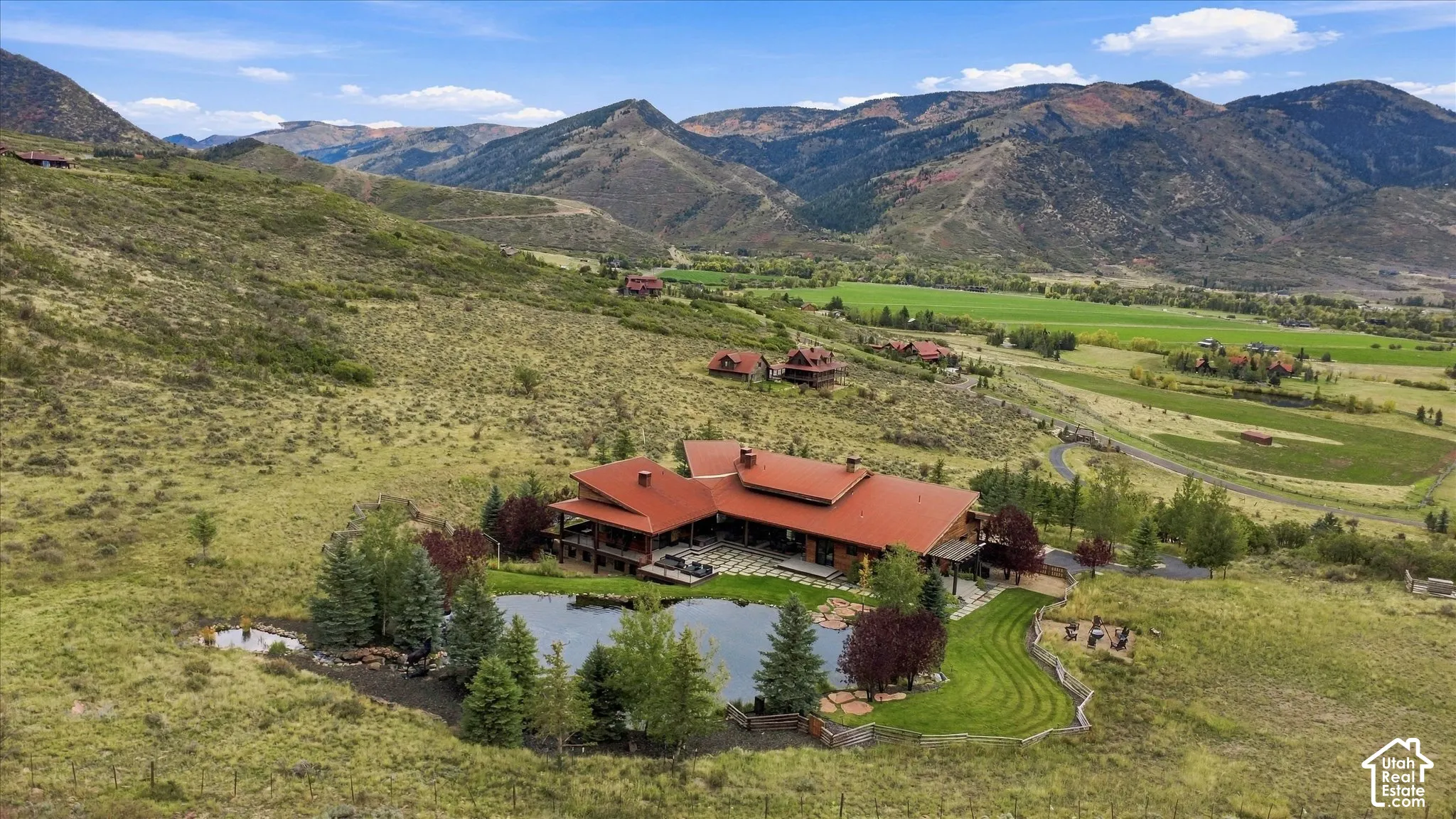 Expansive property featuring a private pond, surrounding trees, and a terraced lawn area