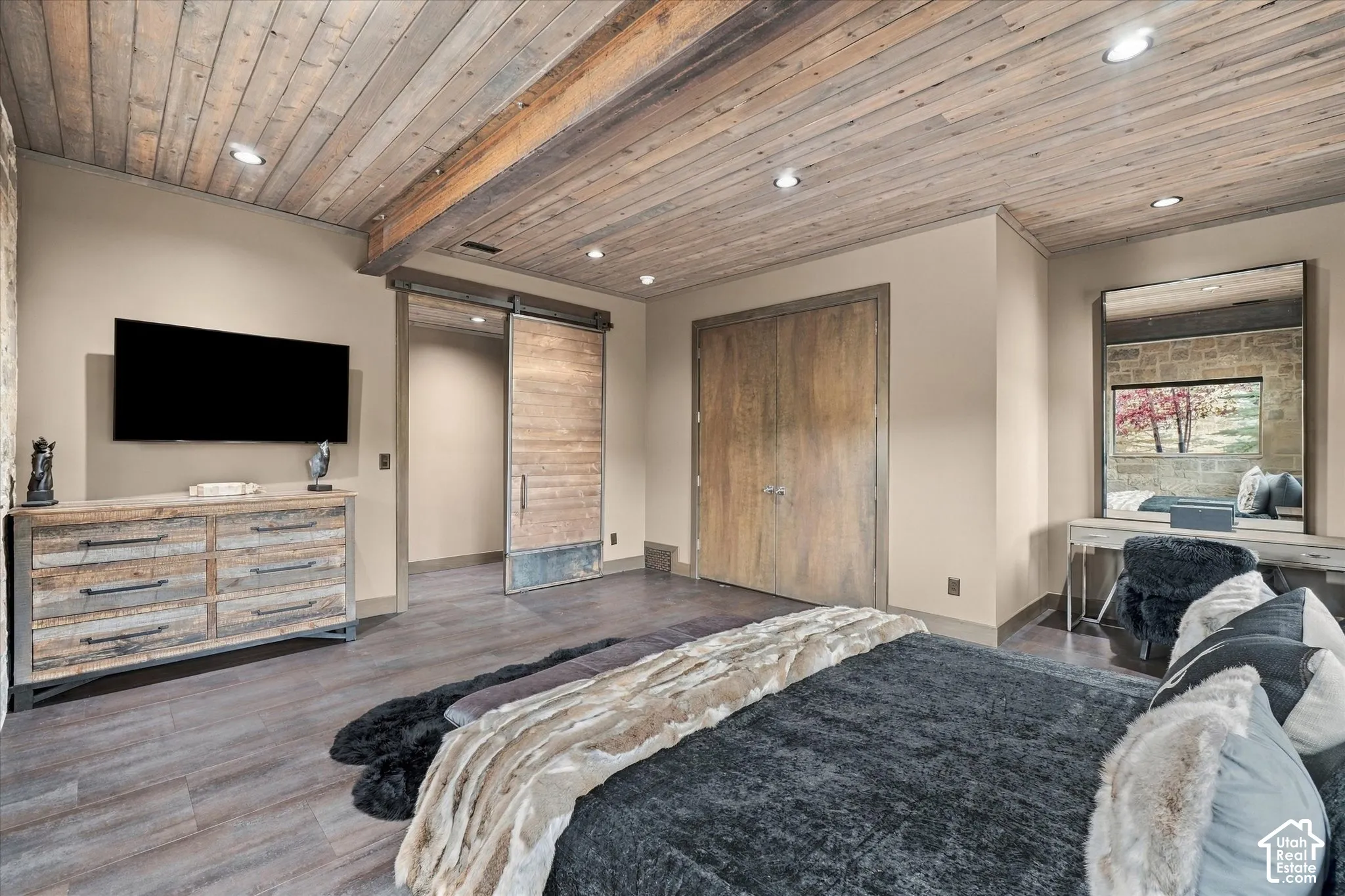 Wood-finish flooring with a wood-plank ceiling, exposed wood beam, and recessed lighting