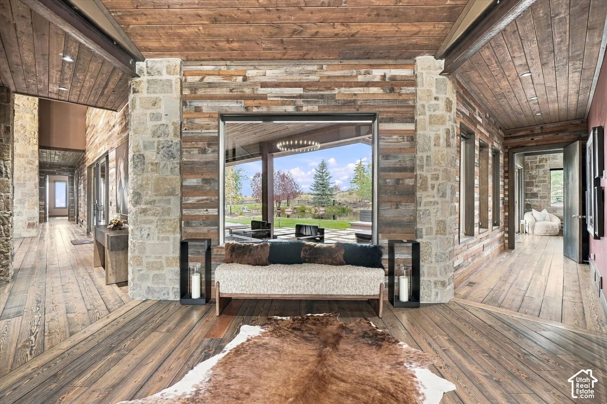 Extensive wood-finish flooring, stone wall accents, and wood panel ceilings