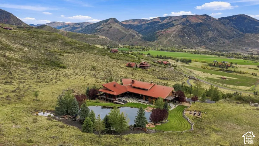 Expansive property featuring a private pond, surrounding trees, and a terraced lawn area