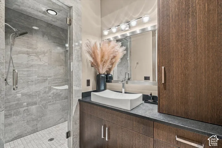 Glass-enclosed shower with large-format stone-finish tiling