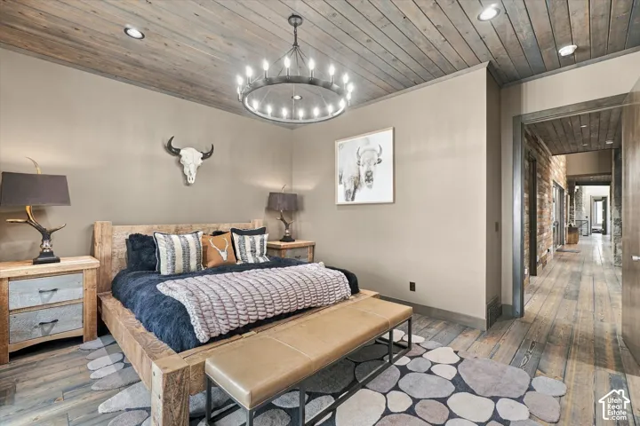 Wood-plank ceiling and flooring, recessed lighting, and a chandelier-style fixture