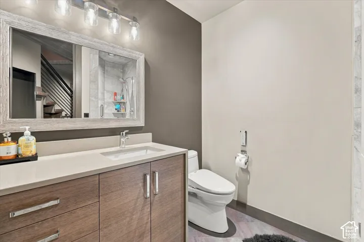 Wood-finish vanity with an integrated sink, light-toned countertop, and framed mirror