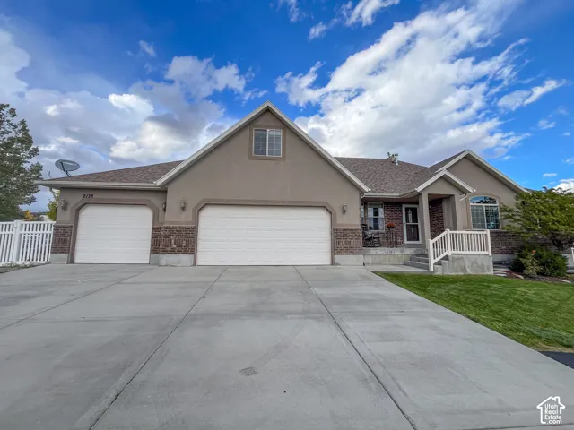 Stucco and brick exterior with a three-car garage