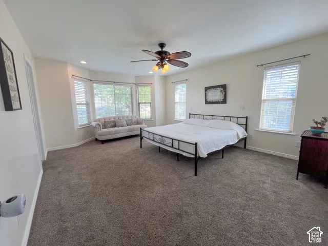 Bay window with multiple windows, recessed lighting, and a ceiling fan with integrated lighting