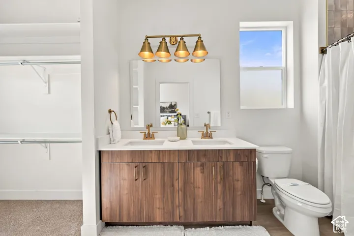 Dual vanity with wood-finish cabinetry and gold-finish fixtures