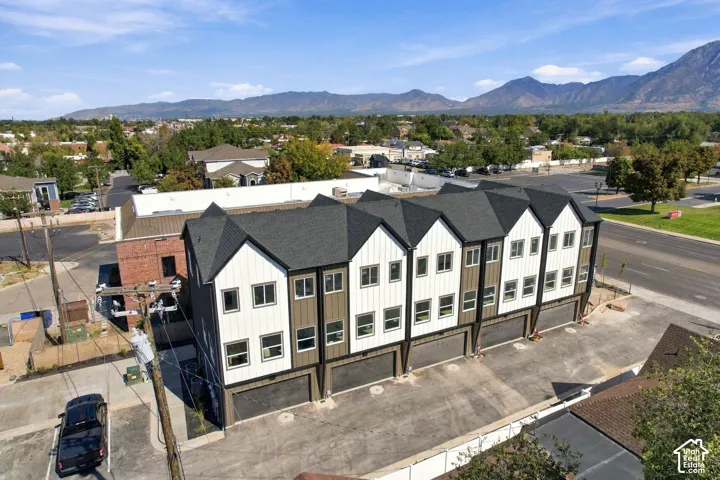 Modern townhome complex featuring multi-pane windows, individual attached garages, and a pitched roofline