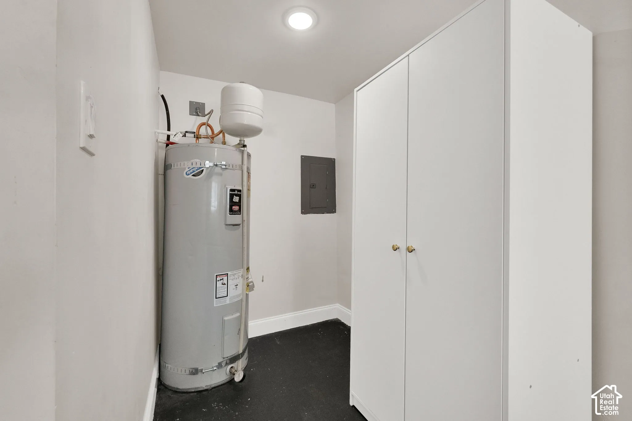 Built-in storage cabinet with brass hardware, ceiling-mounted lighting, and a water heater