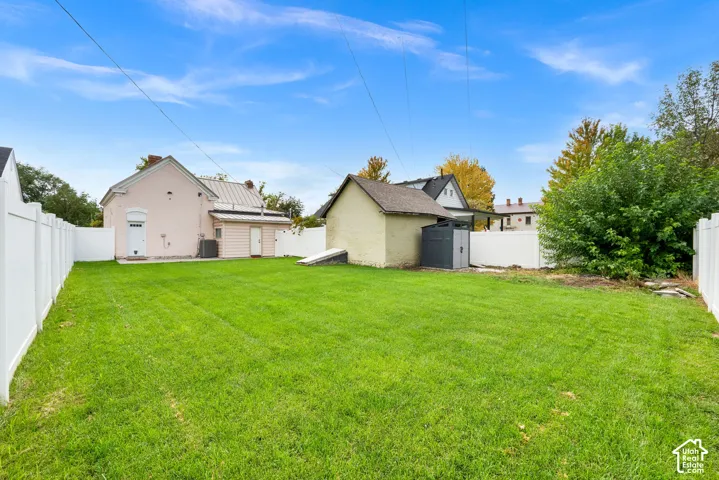 Expansive grassy yard with white privacy fencing