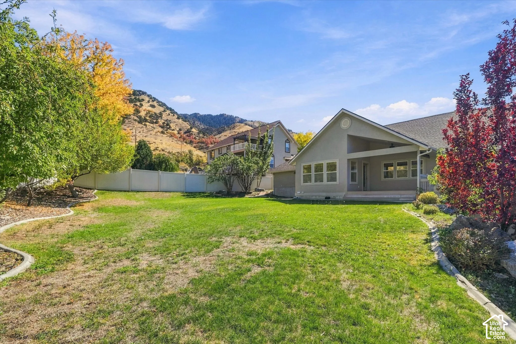Expansive lawn with mature trees and a privacy fence
