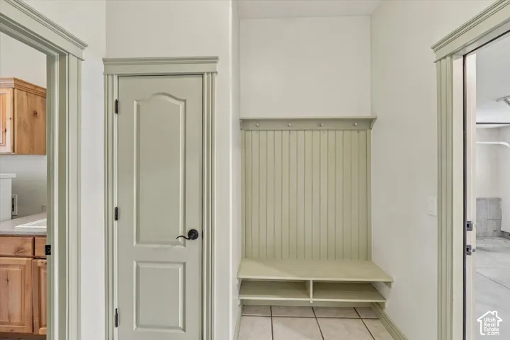 Built-in hall tree with beadboard paneling, integrated bench, and coat hooks