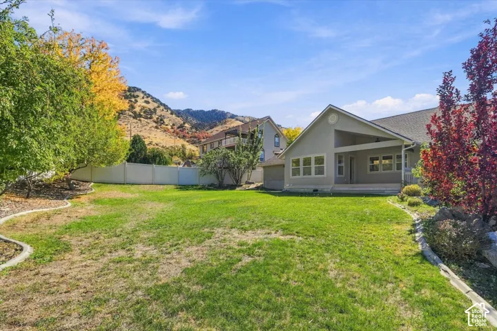Expansive lawn with mature trees and a privacy fence