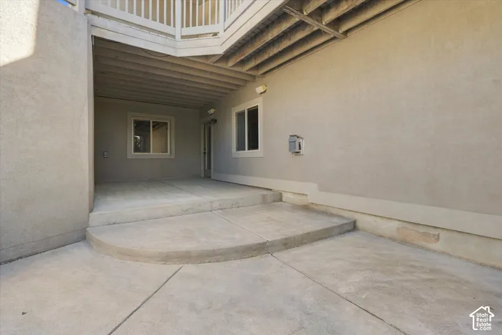 Covered concrete patio with recessed lighting and stucco exterior
