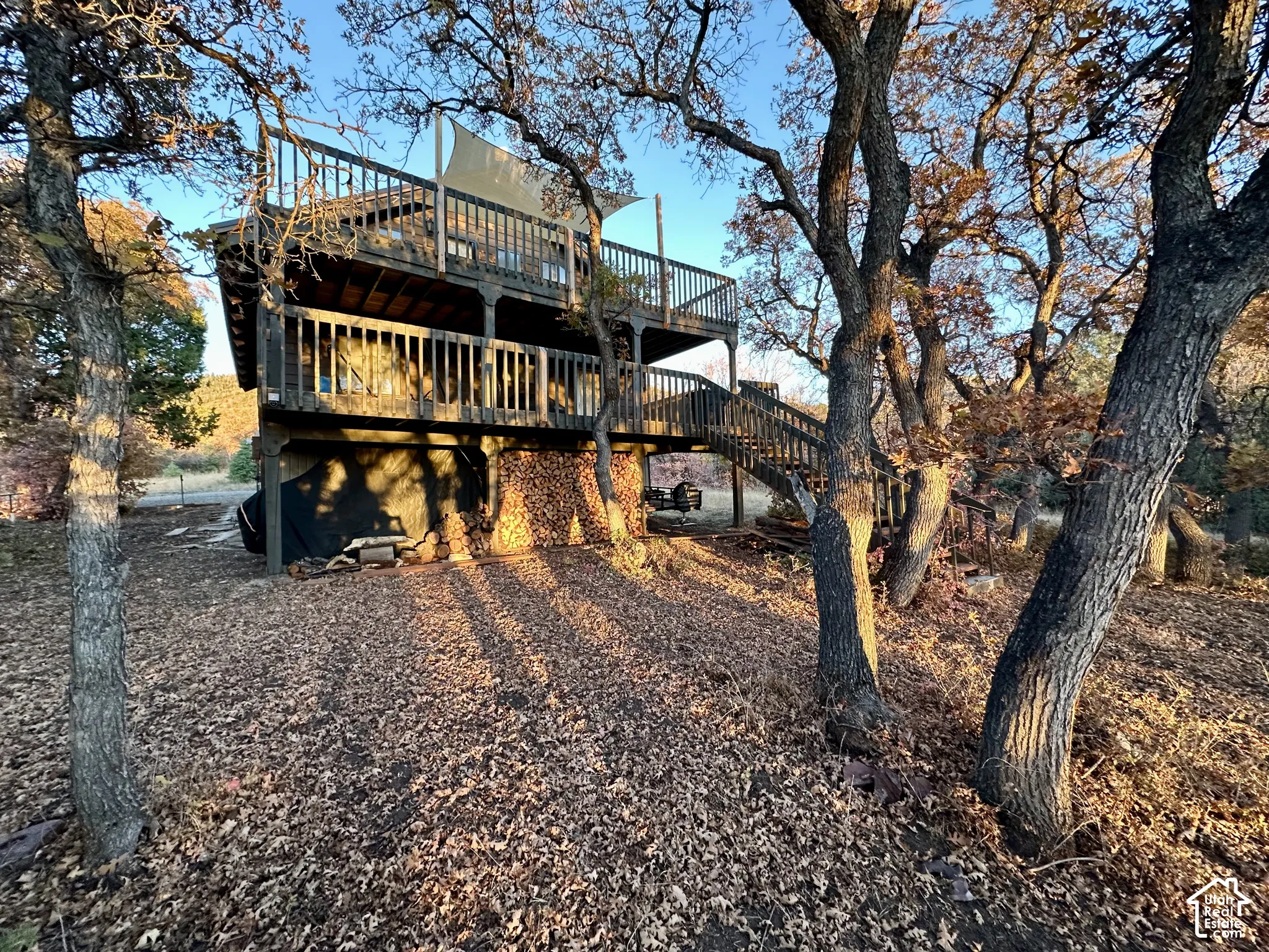 Two-story property with multiple outdoor decks, wood railings, and an exterior staircase