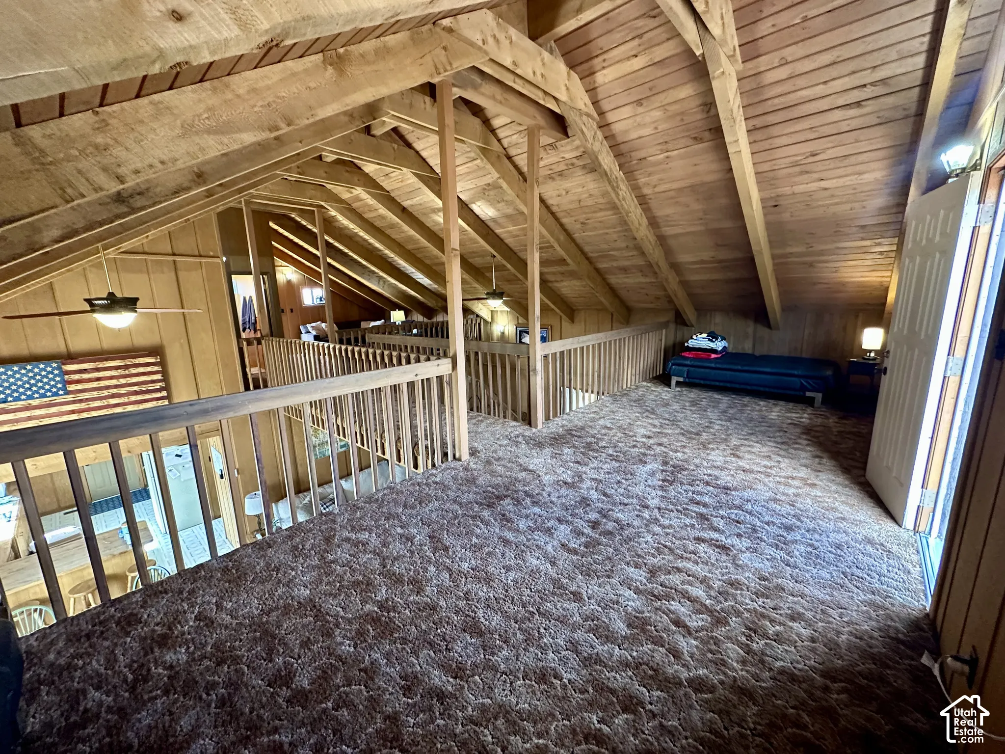 Vaulted wood-paneled ceilings, natural wood beams, and wood railings with balusters