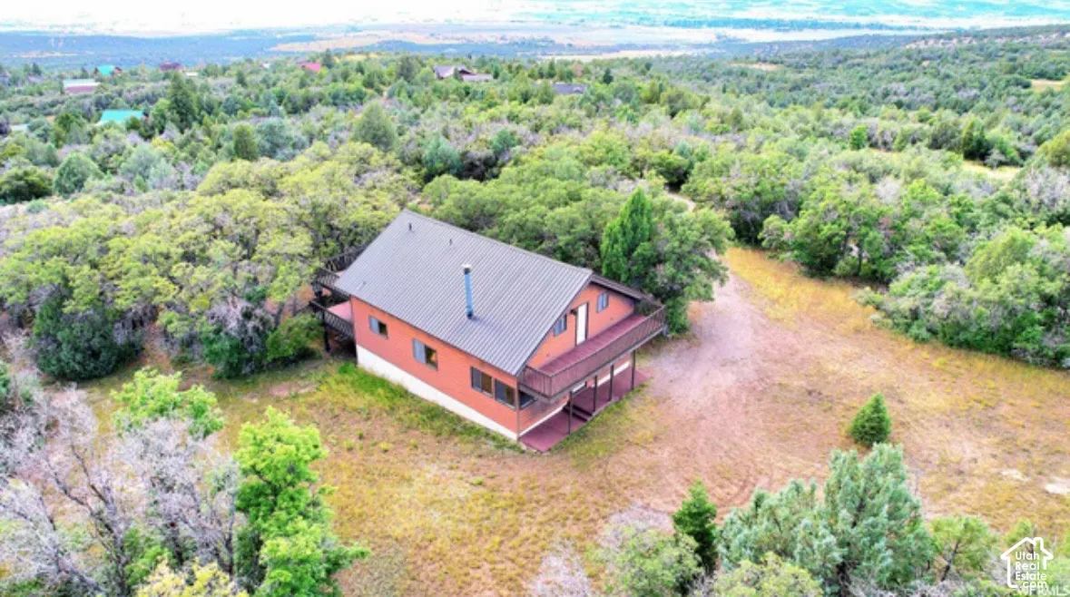 Wood-sided home featuring a metal roof and an upper-level deck