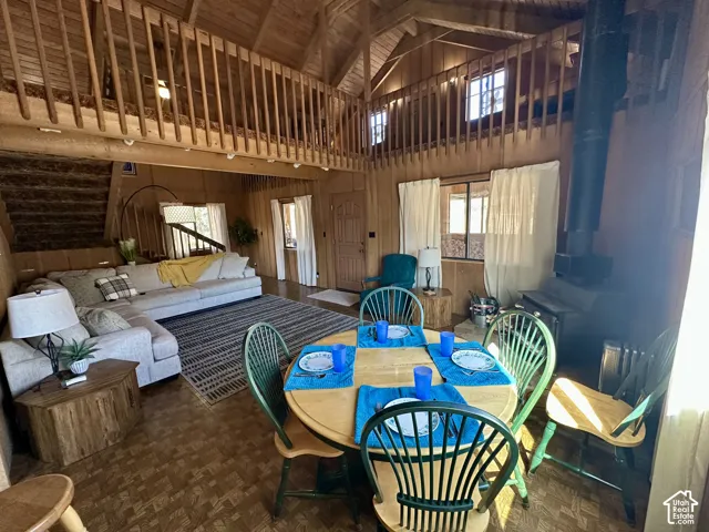 Vaulted wood-paneled ceilings with exposed beams, wood-finish flooring, and a second-story loft with wood railing