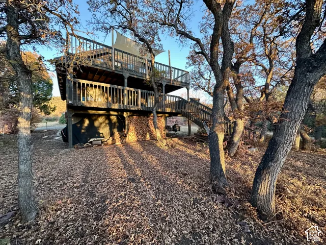 Two-story property with multiple outdoor decks, wood railings, and an exterior staircase