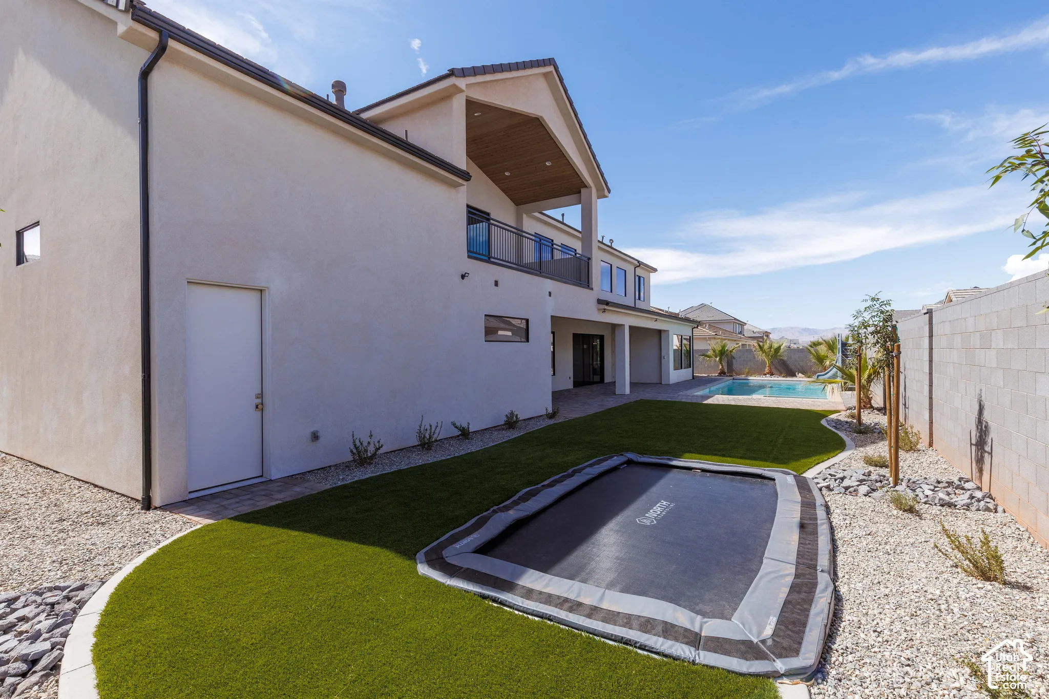 Exterior stucco finish with dark rain gutters