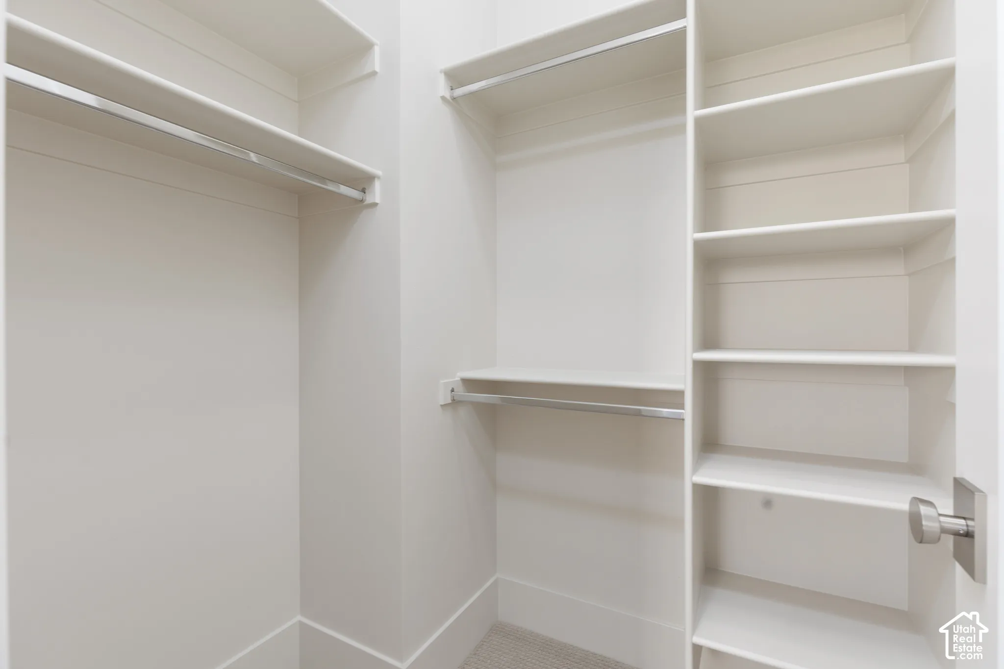 Built-in closet system featuring multiple hanging rods, extensive shelving, and neutral wall tones