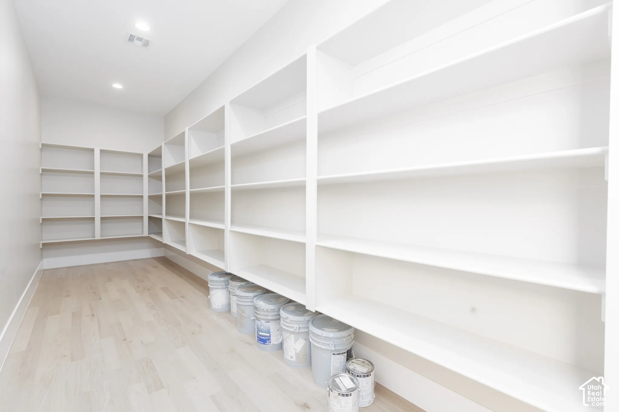 Extensive built-in shelving, recessed ceiling lighting, and wood-finish flooring