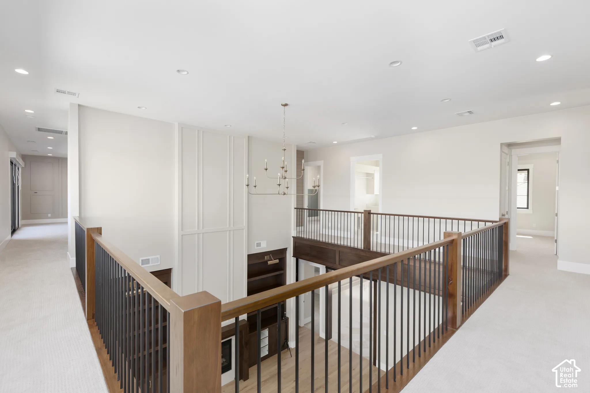 Spacious upper-level landing with carpeted flooring