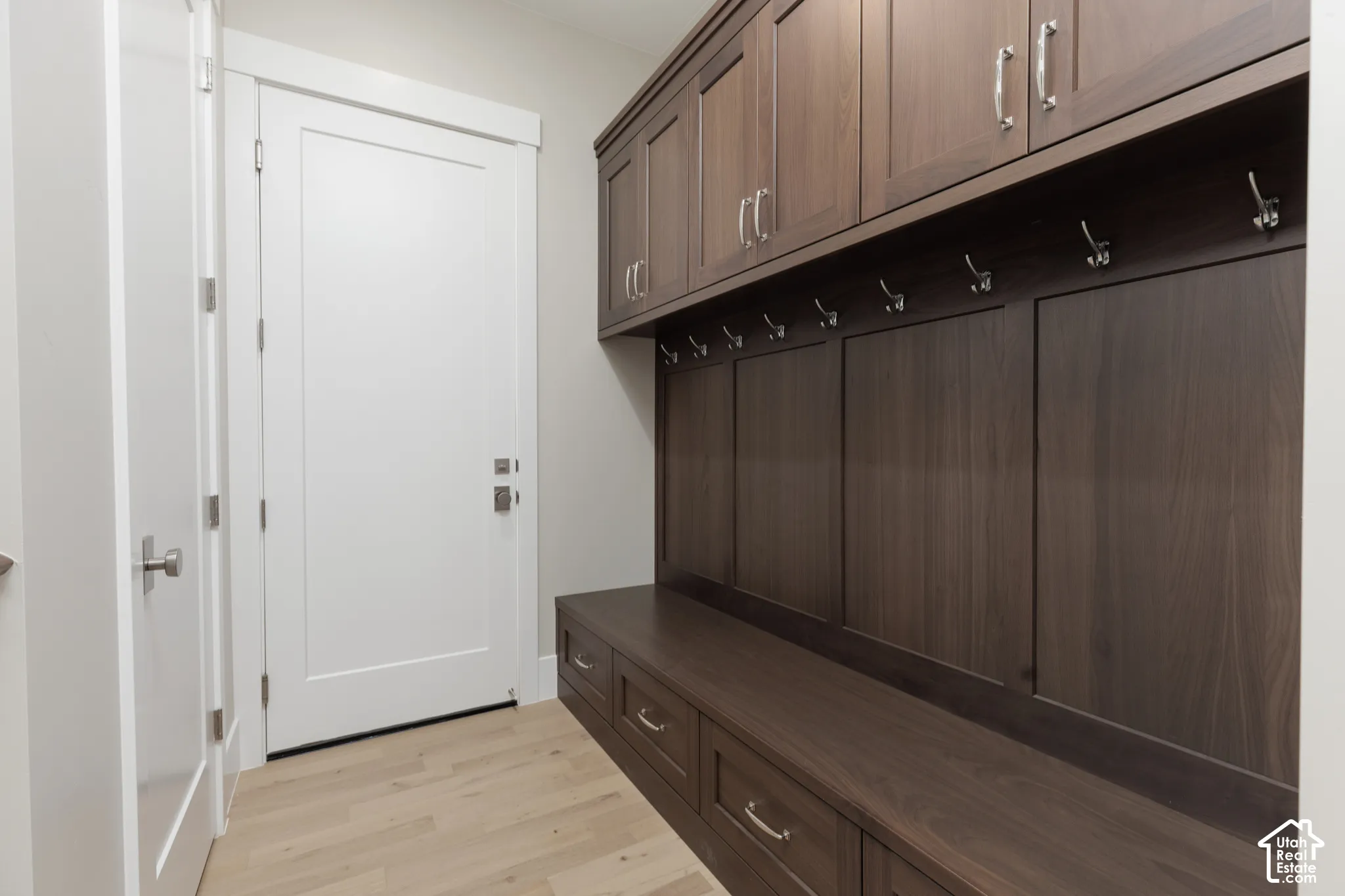 Built-in dark wood-finish cabinetry, integrated bench seating with drawer storage, and a light wood-finish flooring