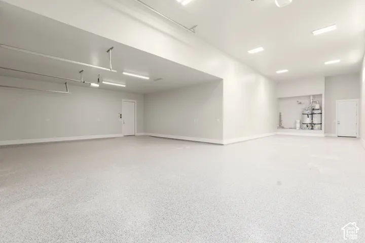 Expansive garage with durable epoxy flooring, overhead lighting, and white walls