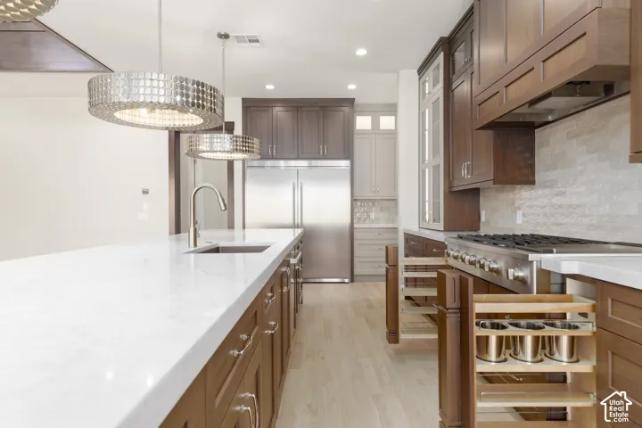 White countertop island with an undermount sink and gooseneck faucet