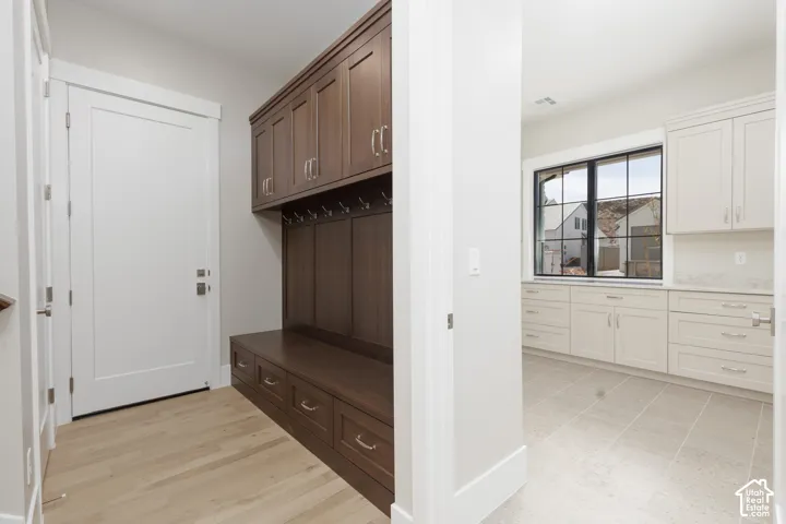 Built-in storage solutions with dark wood-finish cabinetry, integrated seating, and metal coat hooks
