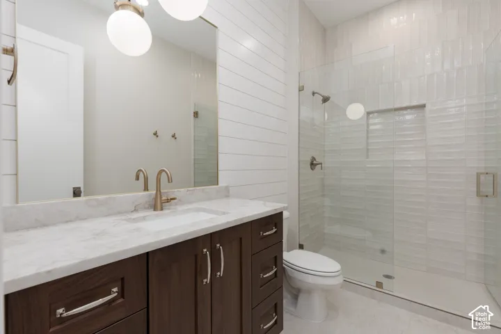 Walk-in shower with clear glass enclosure and tiled walls